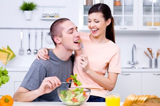 kız, güç için adamı vitamin salatası ile besliyor. 